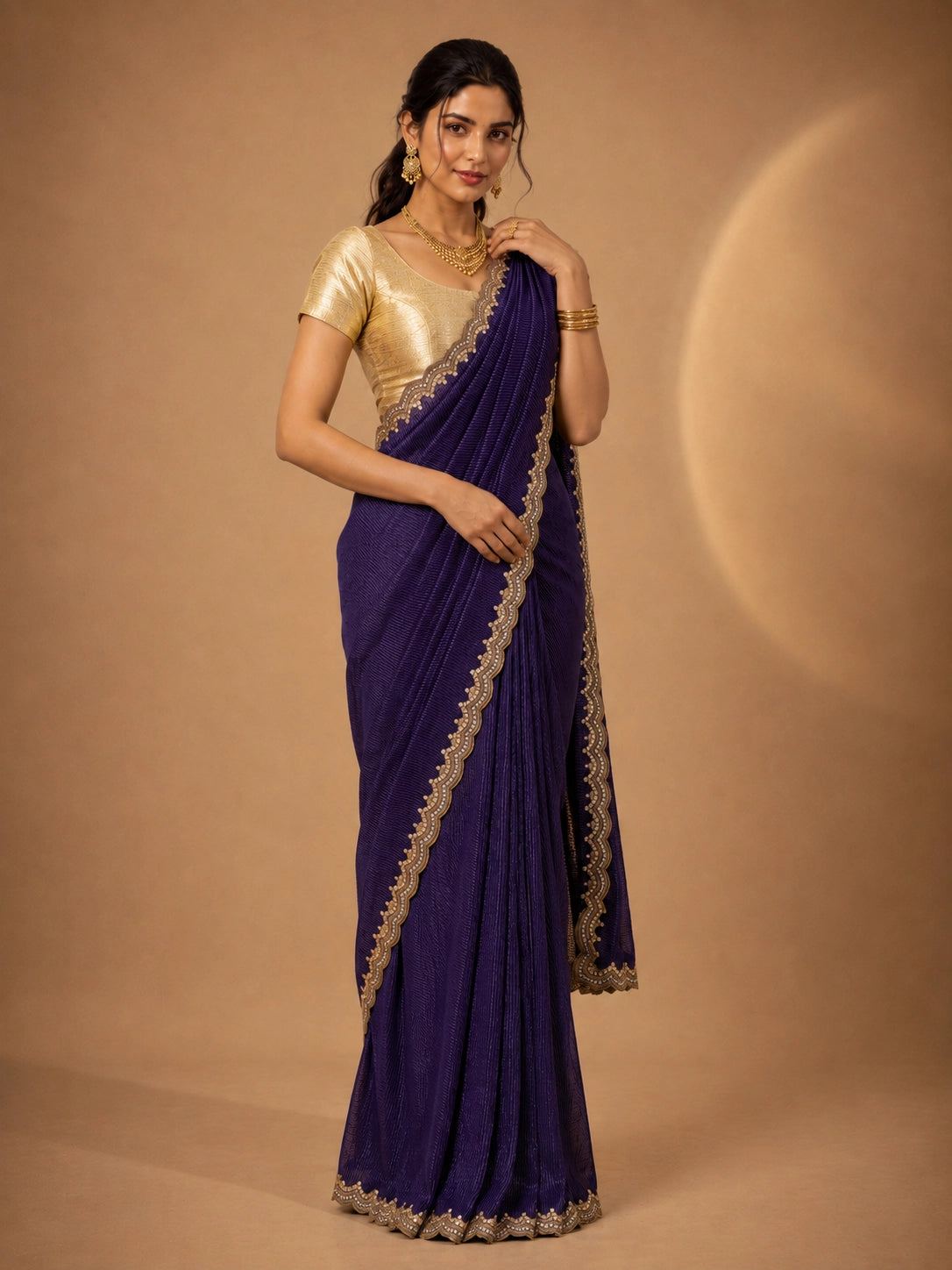 Woman wearing a vibrant purple pleated saree with an embellished border and a golden blouse.