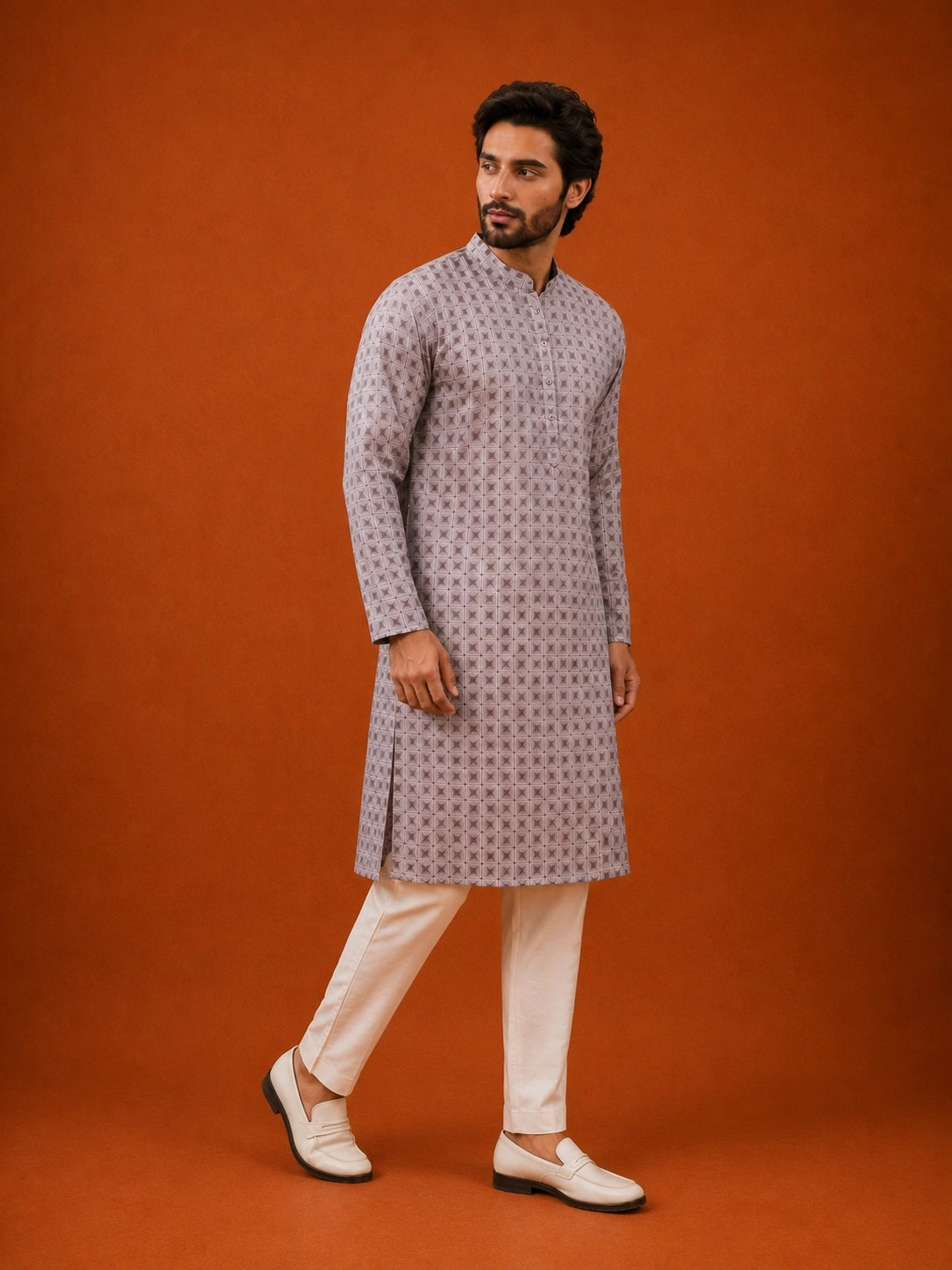 Man wearing a slaty patterned kurta with a mandarin collar, paired with cream pajama.