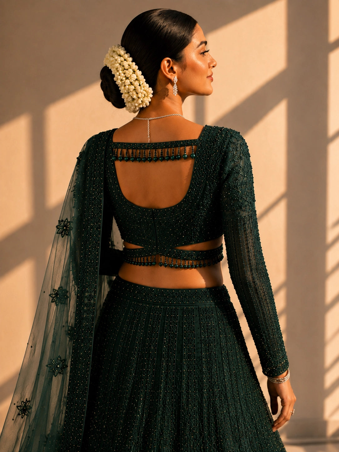 Woman in an exquisite dark green heavily embellished  INDO lehenga choli set.