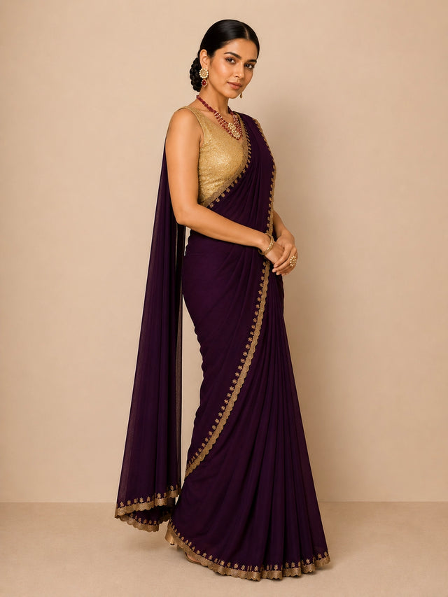 Woman in elegant wine saree with golden embroidered border and matching blouse