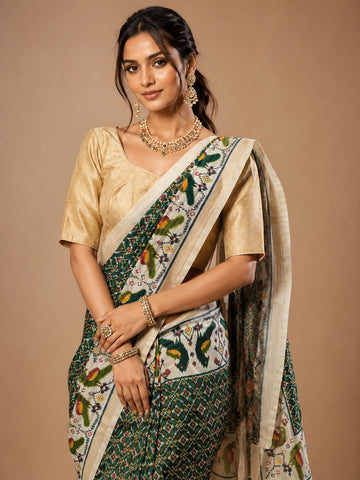 Woman in an elegant green Patola saree with a gold blouse and traditional jewelry.