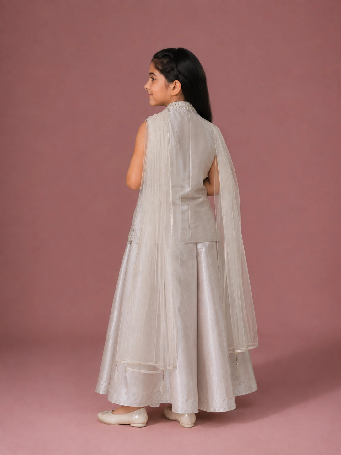 A young girl in a cream embroidered sleeveless top and matching wide-leg palazzo pants.
