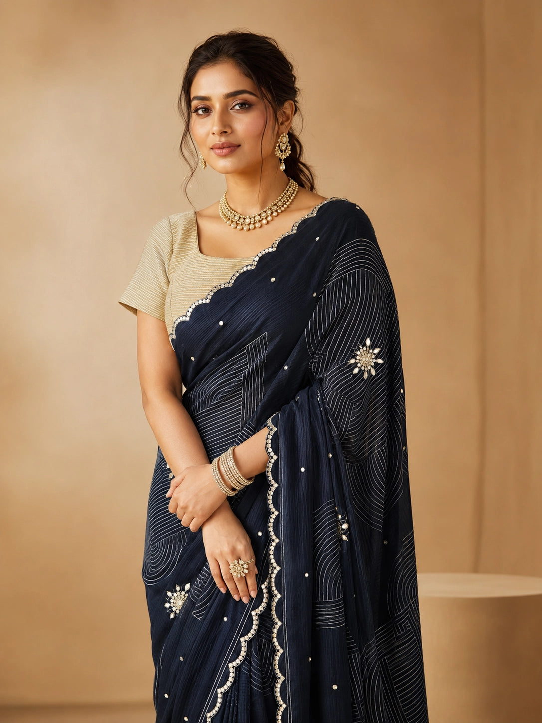 Woman wearing an elegant navy blue embroidered saree with a golden blouse and traditional jewelry.