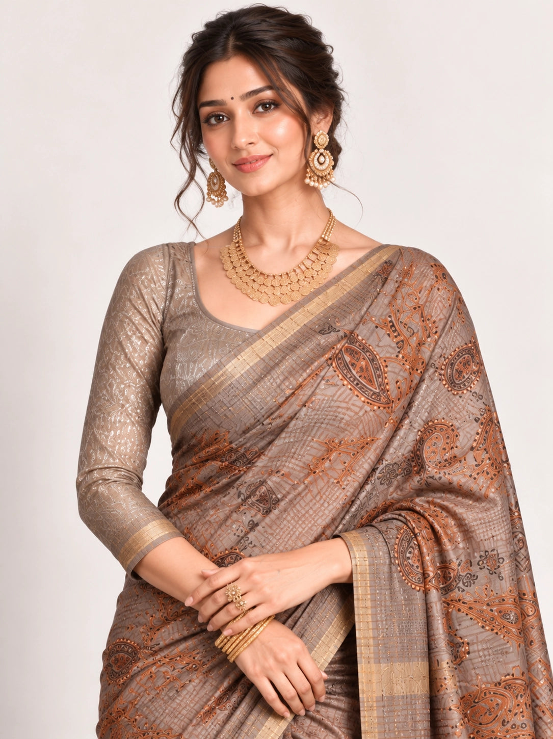Woman in an elegant lavender grey saree with gold border and intricate paisley patterns.