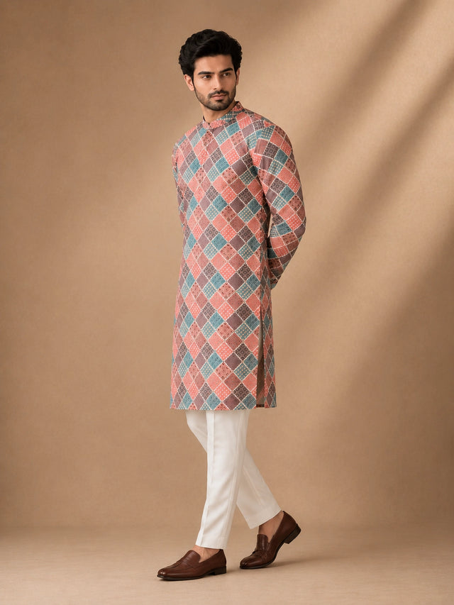 Man in a vibrant geometric diamond print kurta, white pajama, and brown loafers.