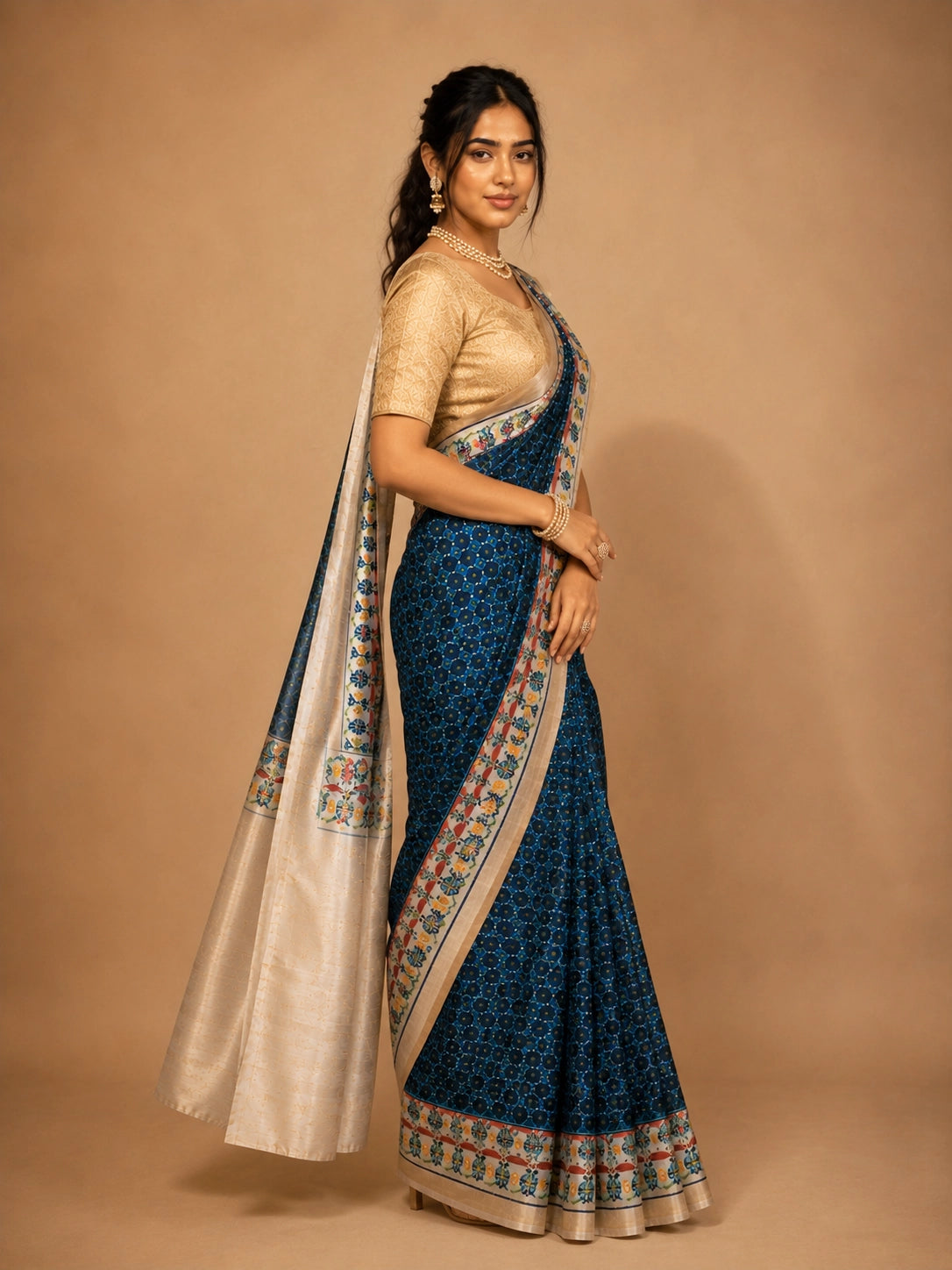Woman in elegant navy blue  ikat saree with golden blouse and traditional jewelry.