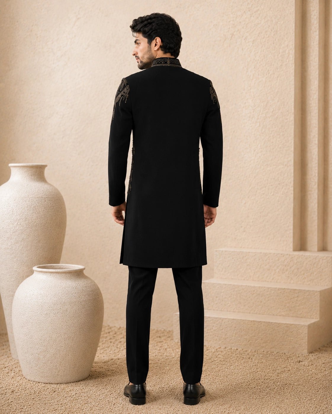 Man wearing a stylish black Indo-Western suit, showcasing intricate details and a modern fit.