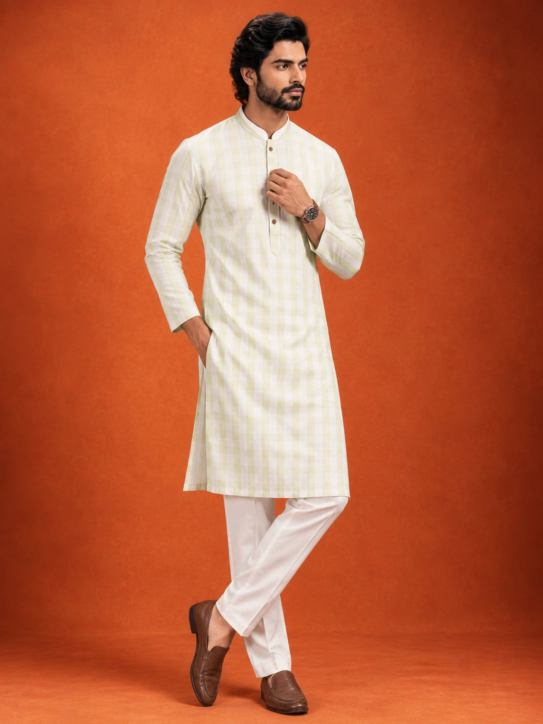 Full-length view of a man in a pista green checkered kurta and white pajama.