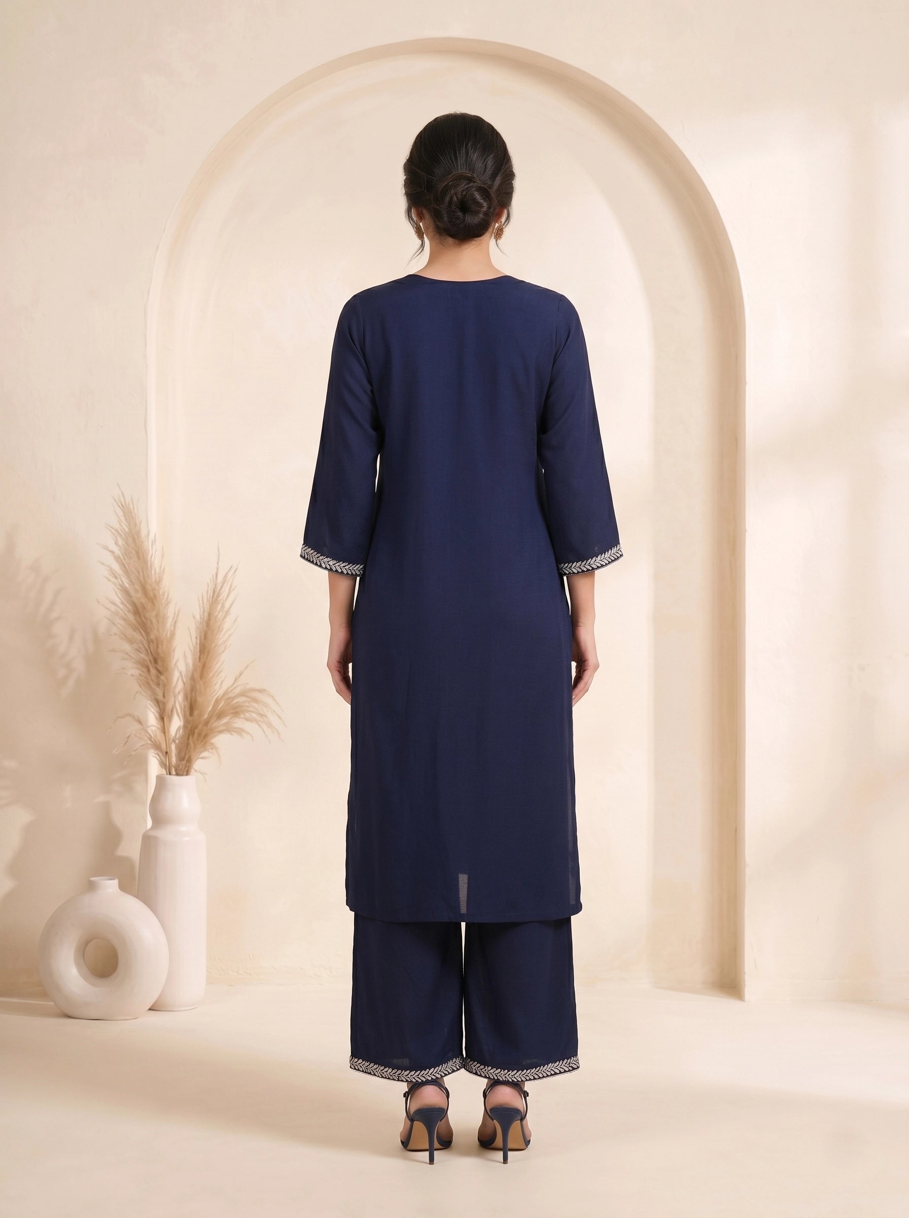 Navy blue embroidered kurti and pants set with a printed dupatta draped over the shoulder.