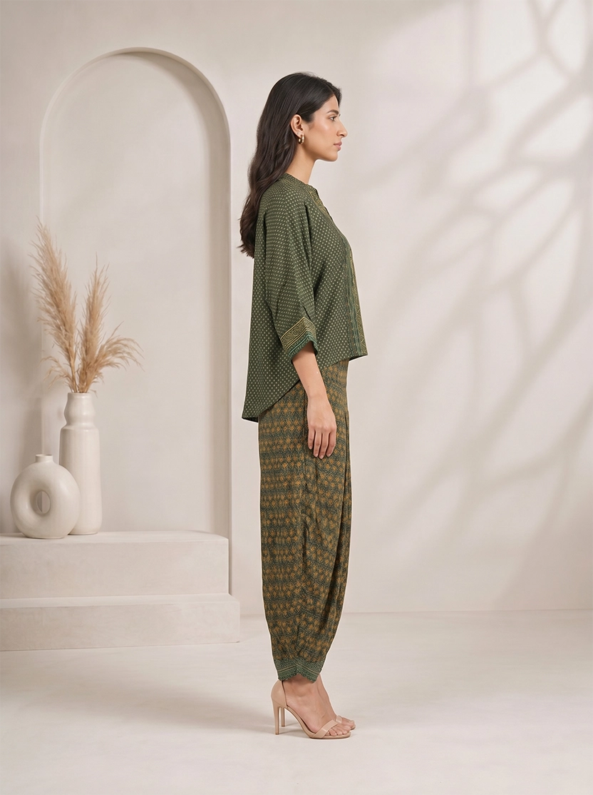 Woman wearing a green printed kurta with flowing sleeves and matching dhoti pants, styled with nude heels.