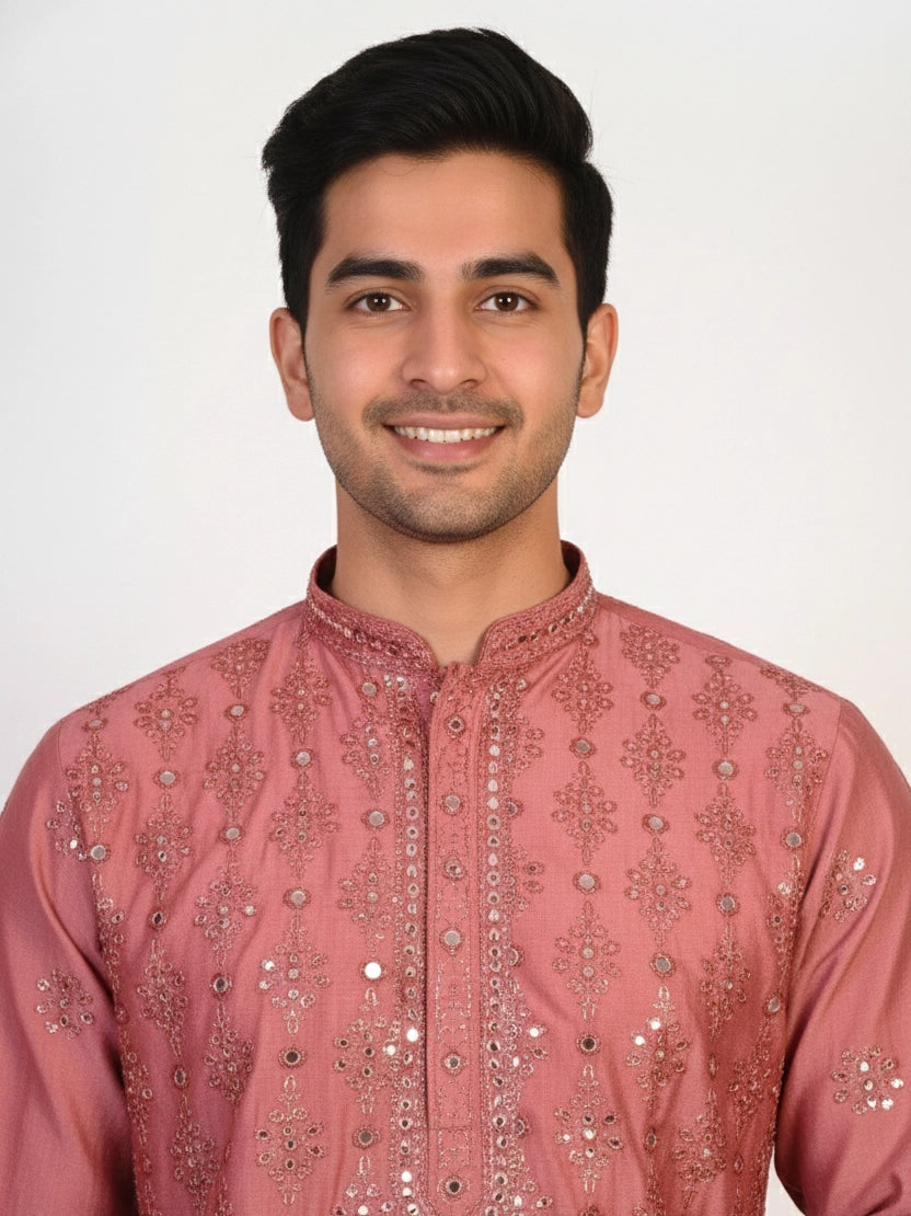 Man wearing a rose embroidered Kurta Pajama with white pants and brown jutti shoes.