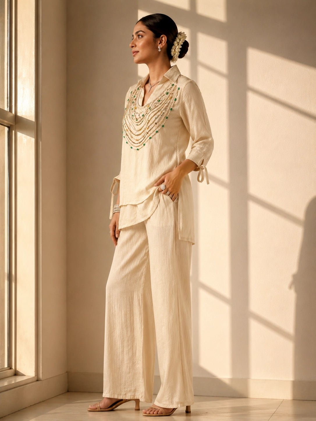 Woman wearing an elegant beige embroidered kurti with wide-leg palazzo pants.