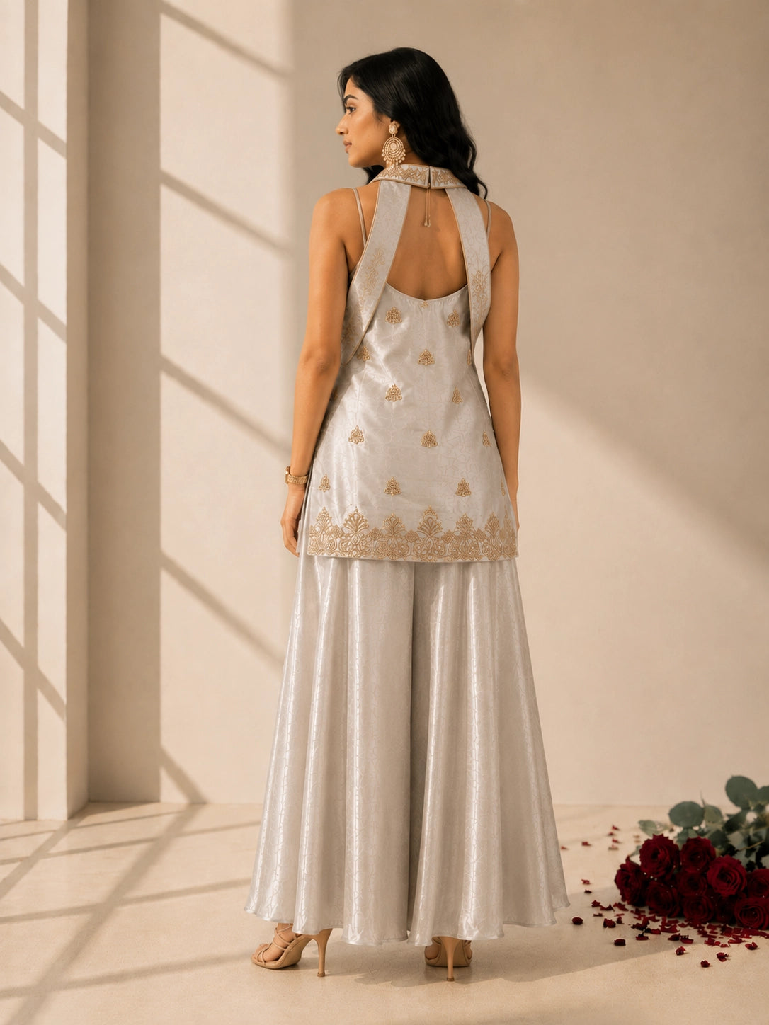 Woman in elegant grey sleeveless kurti with gold embroidery and matching palazzo pants.