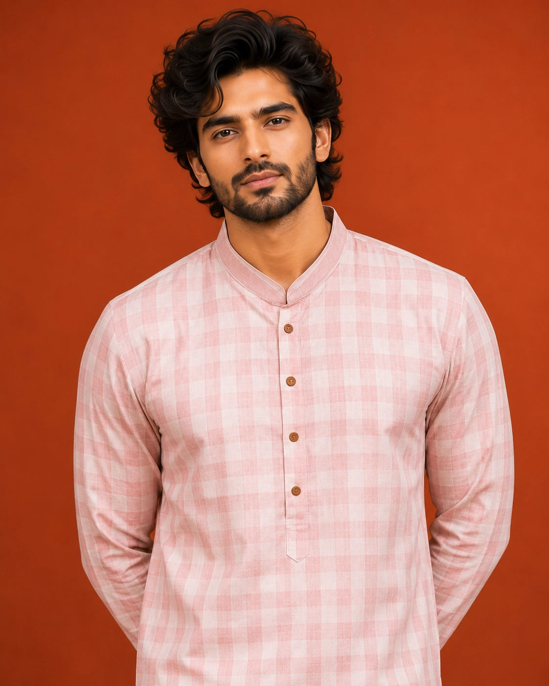 Man wearing a light pink checked kurta with a band collar and white pajama.