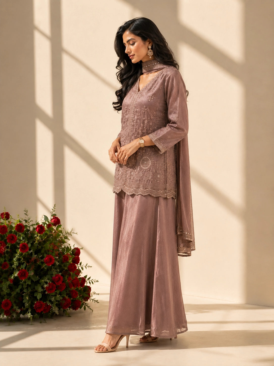 Woman in an elegant onion-colored embroidered kurti set with palazzo pants and matching scarf.