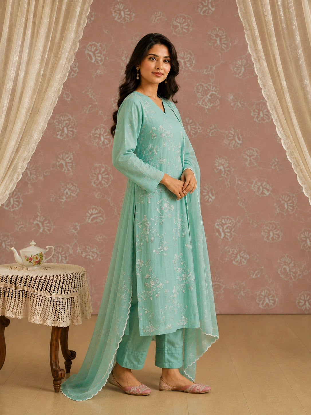 Woman wearing an elegant light green kurti with intricate white floral embroidery.