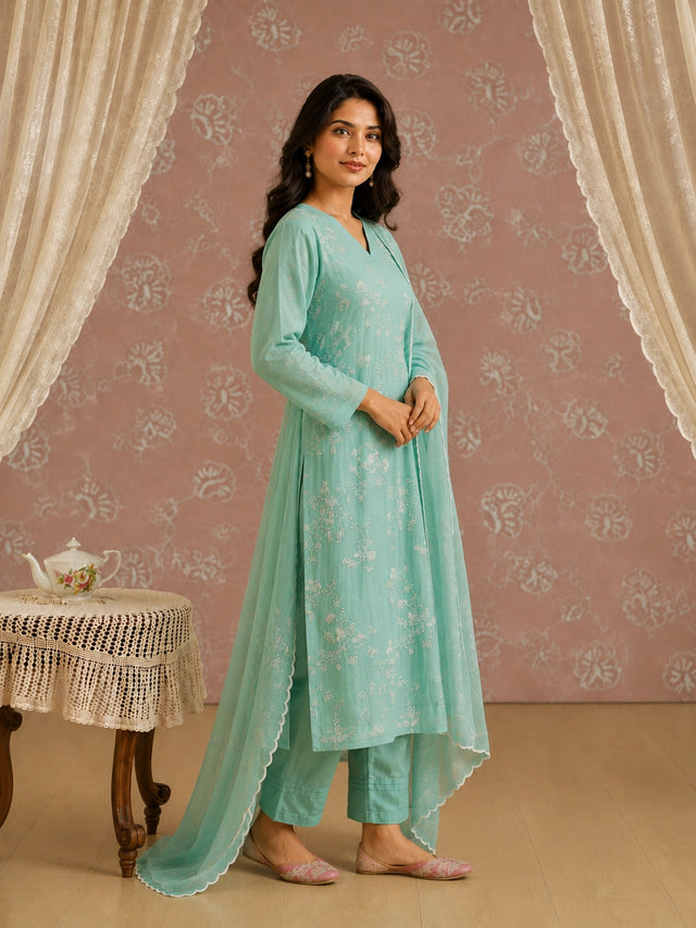 Woman wearing an elegant light green kurti with intricate white floral embroidery.