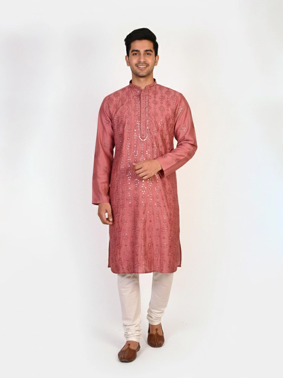 Man wearing a rose embroidered Kurta Pajama with white pants and brown jutti shoes.