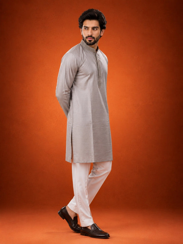 Man in elegant grey kurta with embroidered collar and white pajama set.