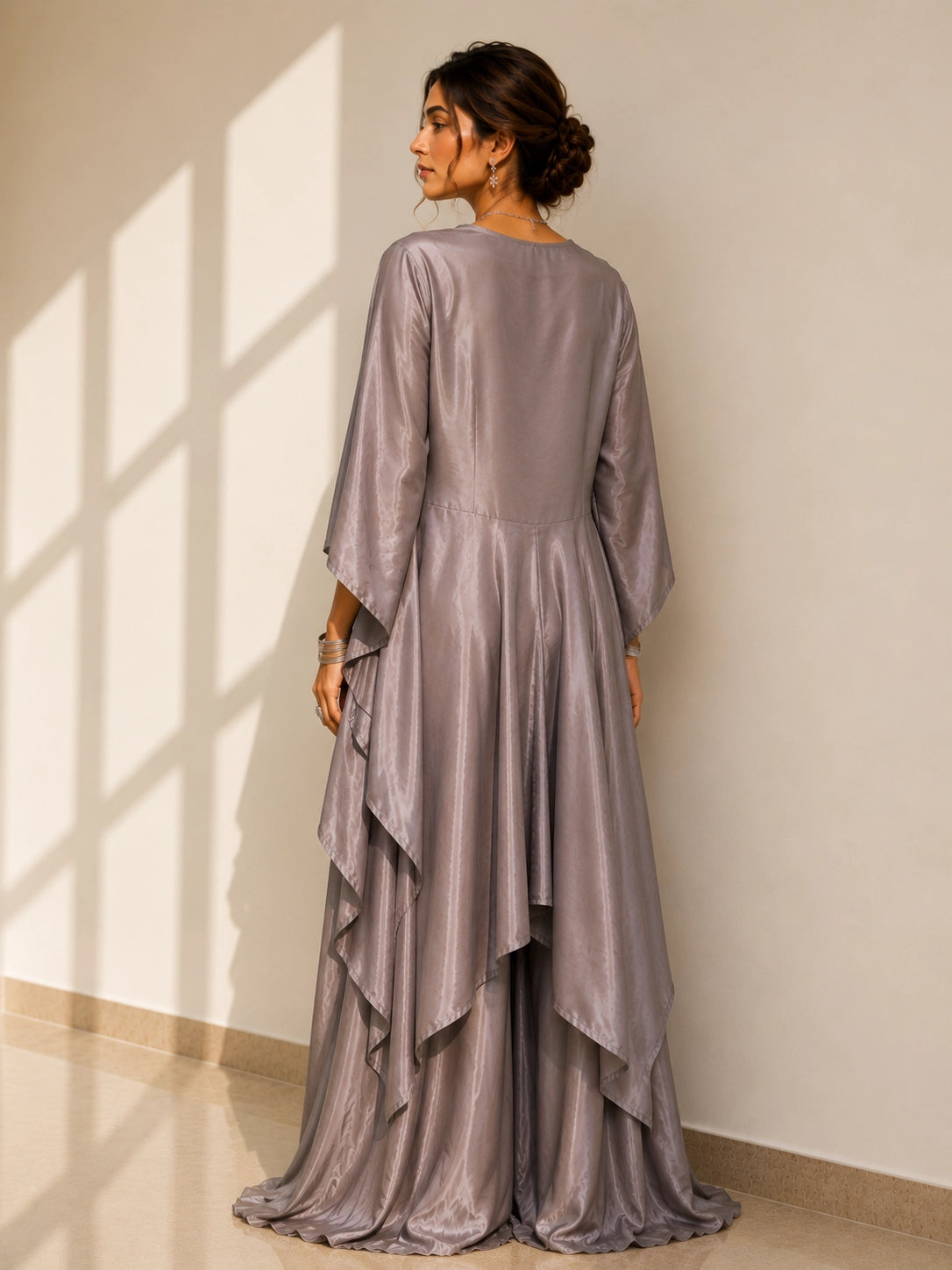 Woman in an elegant onion-colored layered kurti with golden waist detail and matching palazzo pants.