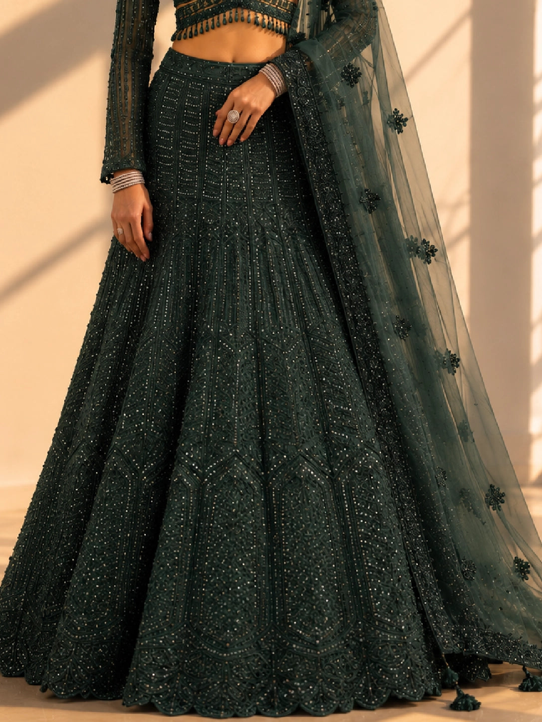 Woman in an exquisite dark green heavily embellished  INDO lehenga choli set.