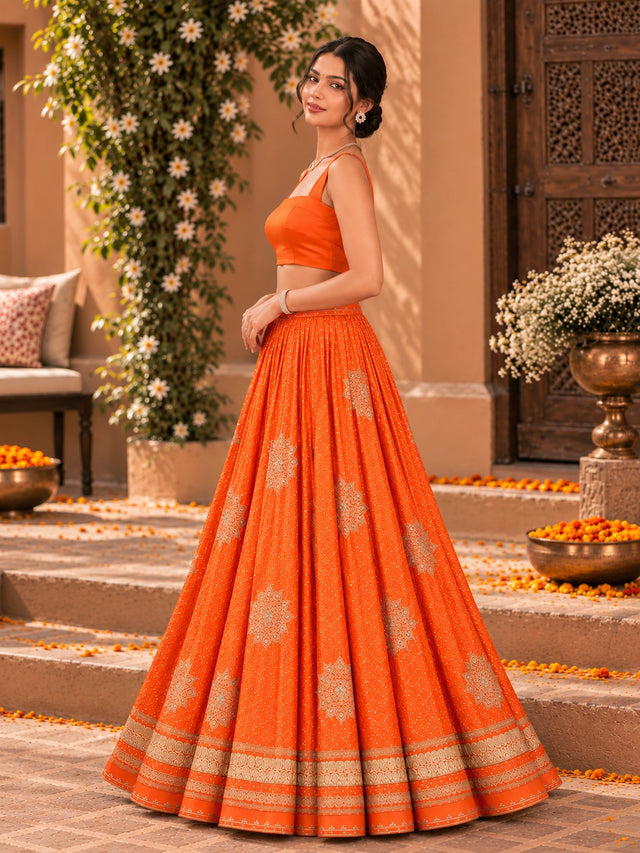 Woman wearing a vibrant rust orange embroidered lehenga choli set with a matching dupatta.