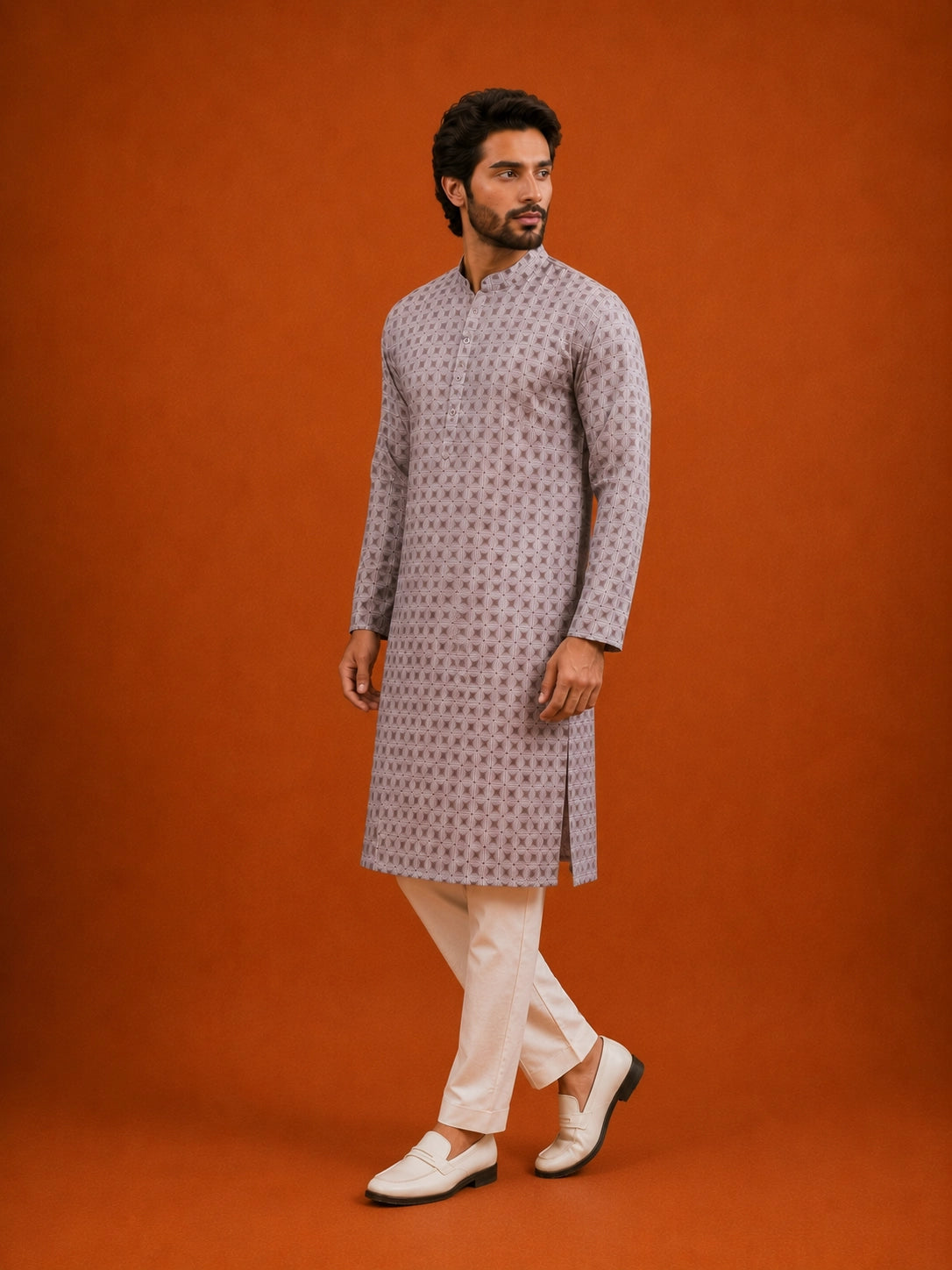 Man wearing a slaty patterned kurta with a mandarin collar, paired with cream pajama.