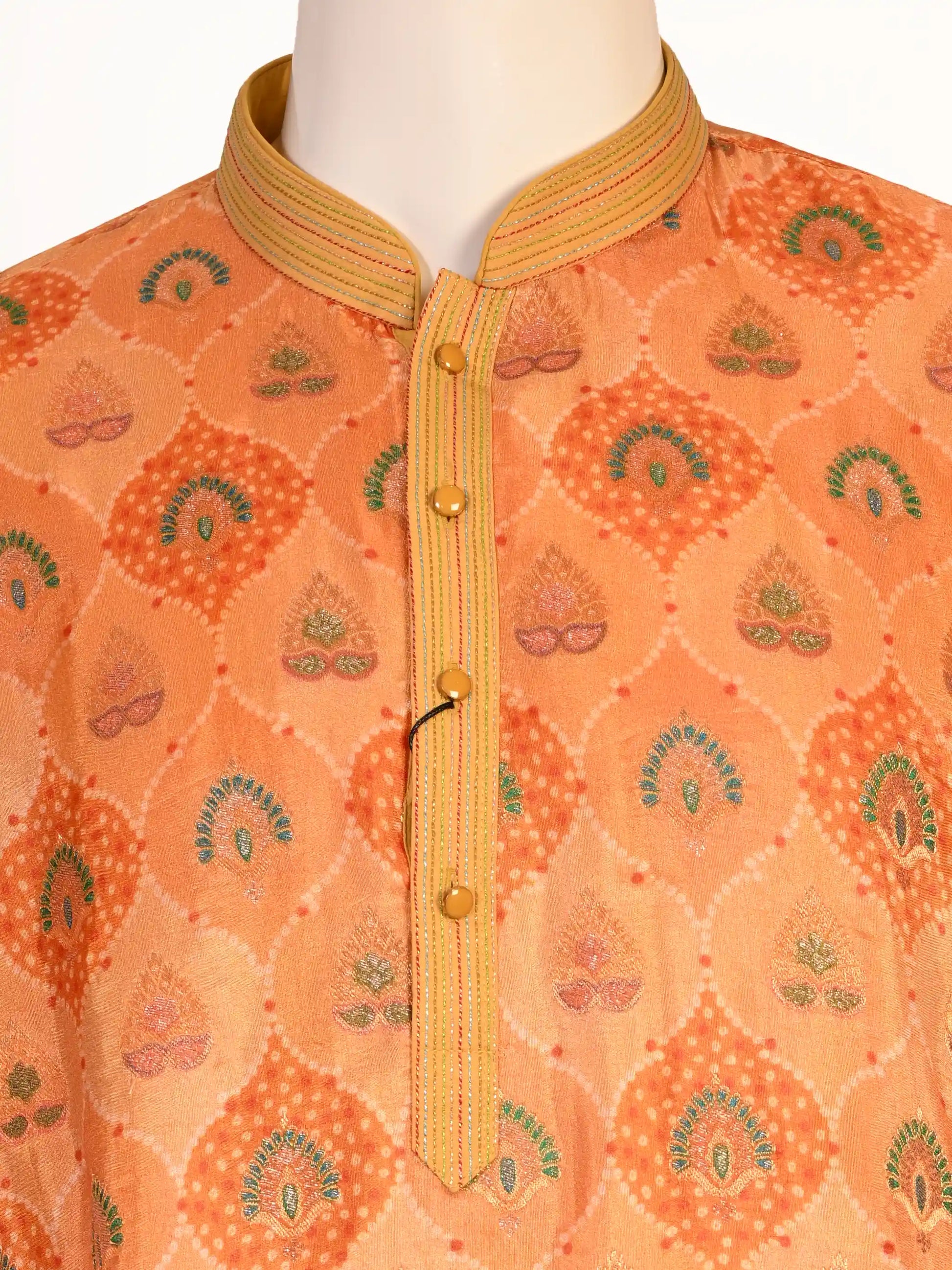 Man wearing an orange embroidered Kurta Pajama with cream pants and brown shoes, showcasing intricate patterns.