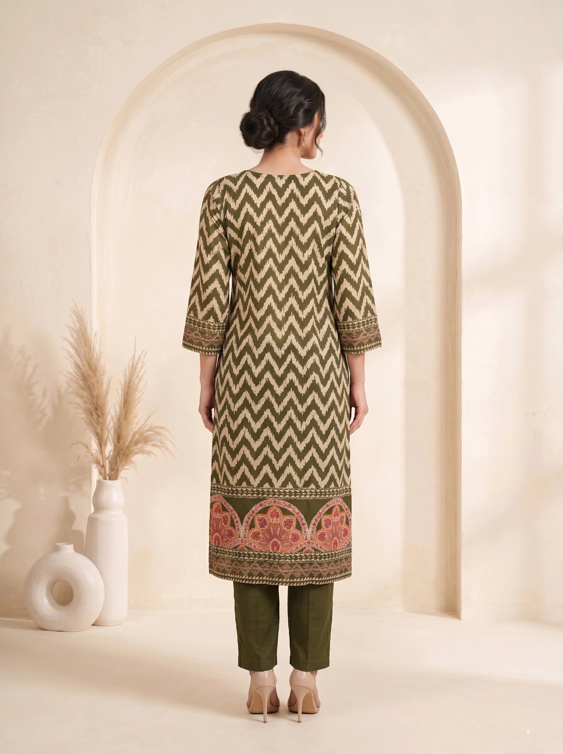 Woman wearing an olive green printed kurti set with palazzo pants and a matching dupatta.
