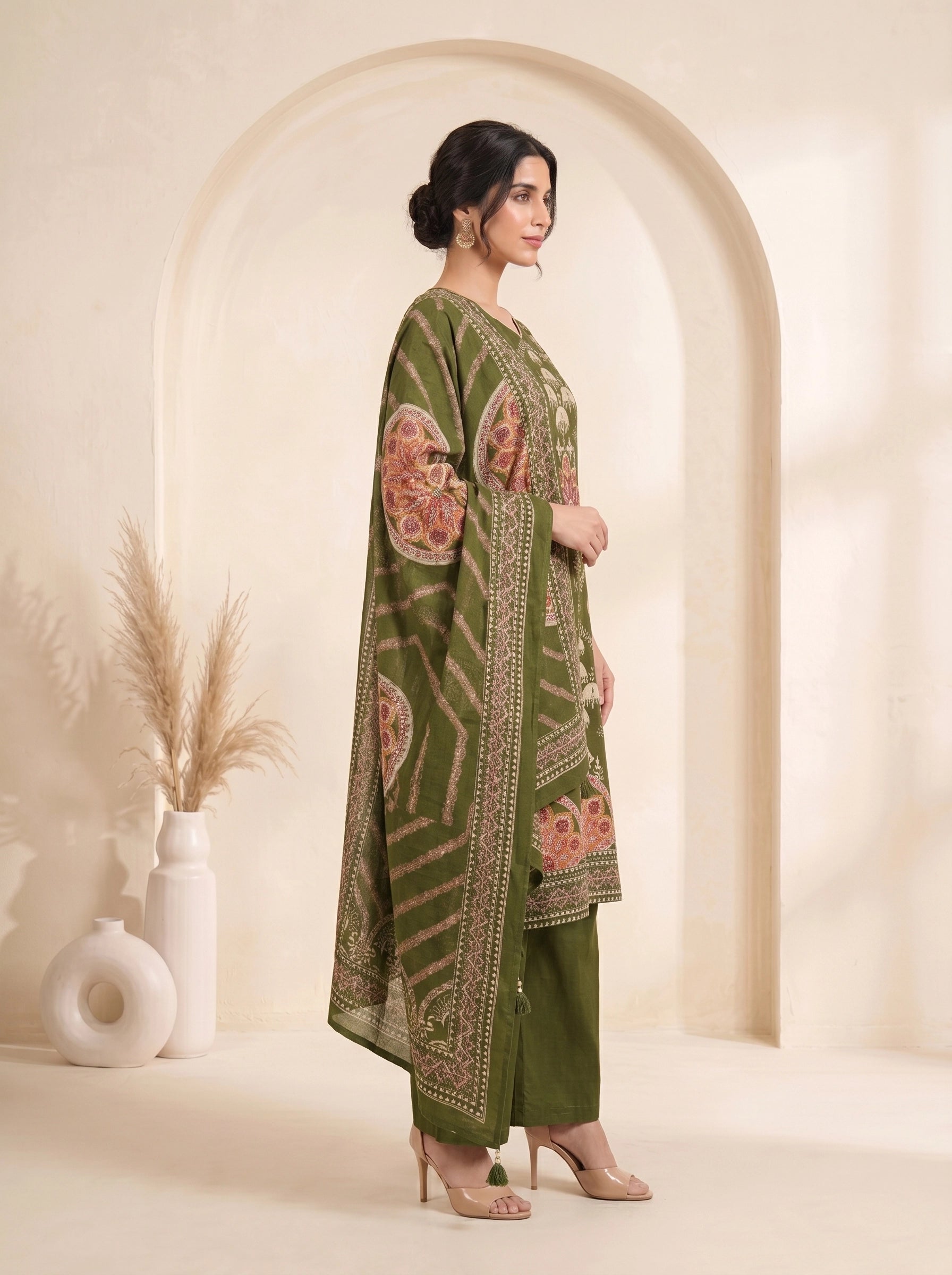 Woman wearing an olive green printed kurti set with palazzo pants and a matching dupatta.