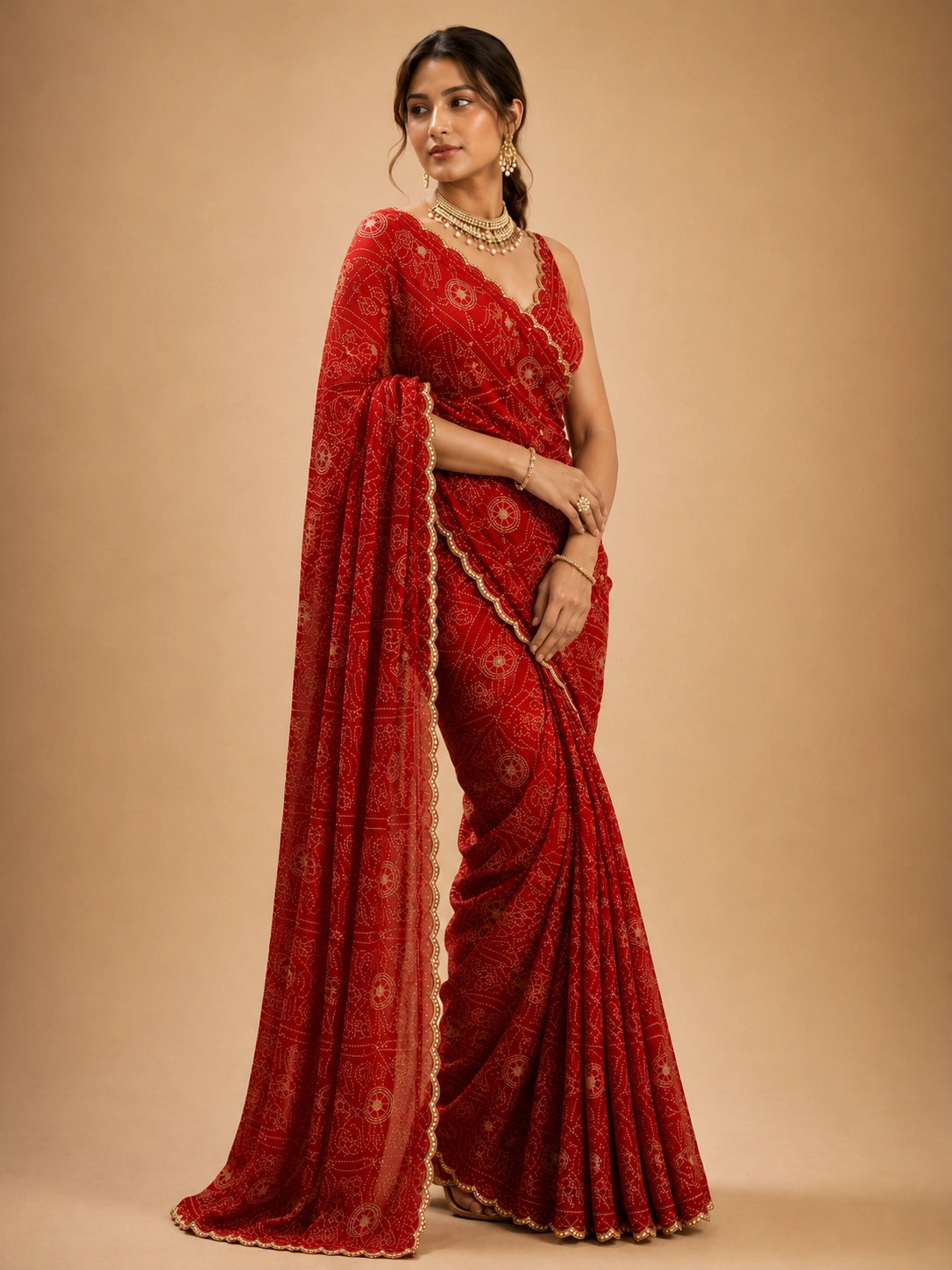 Woman in a vibrant red Bandhani saree with gold patterns and a matching blouse.