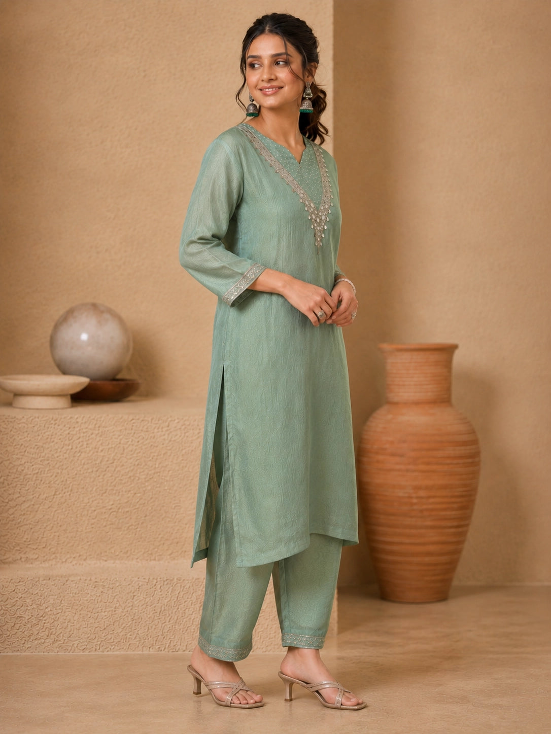 Woman wearing a green embroidered Sharara with silver embellishments on the neckline and cuffs.