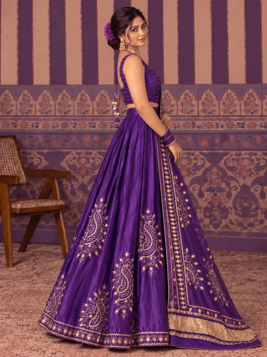 Woman in a vibrant purple embroidered lehenga choli set with gold patterns.