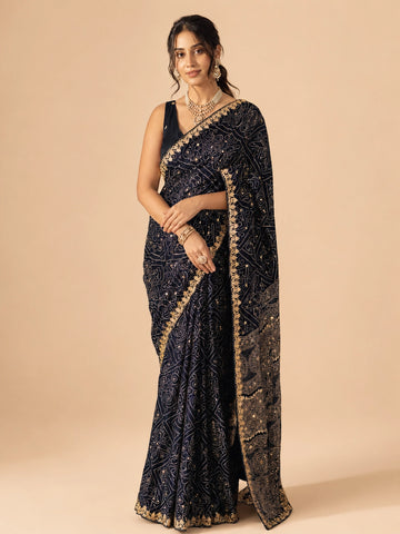Woman in elegant navy blue  saree with gold embroidery and mirror work.