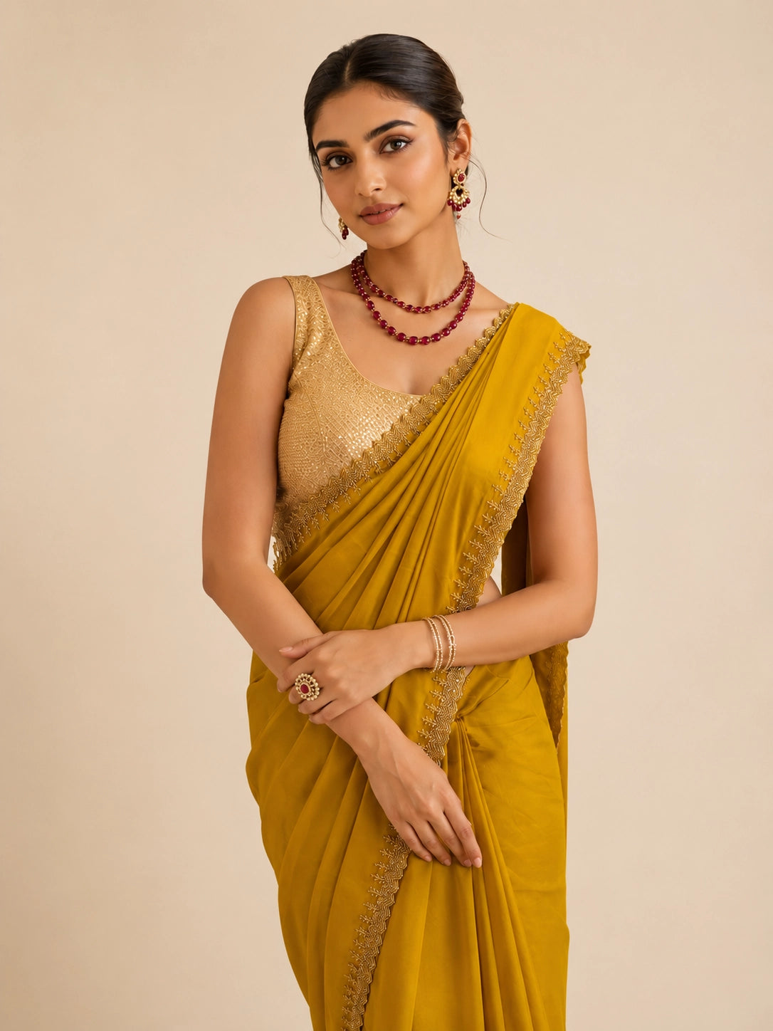 Woman in elegant mustard  saree with delicate embroidered border and golden blouse.