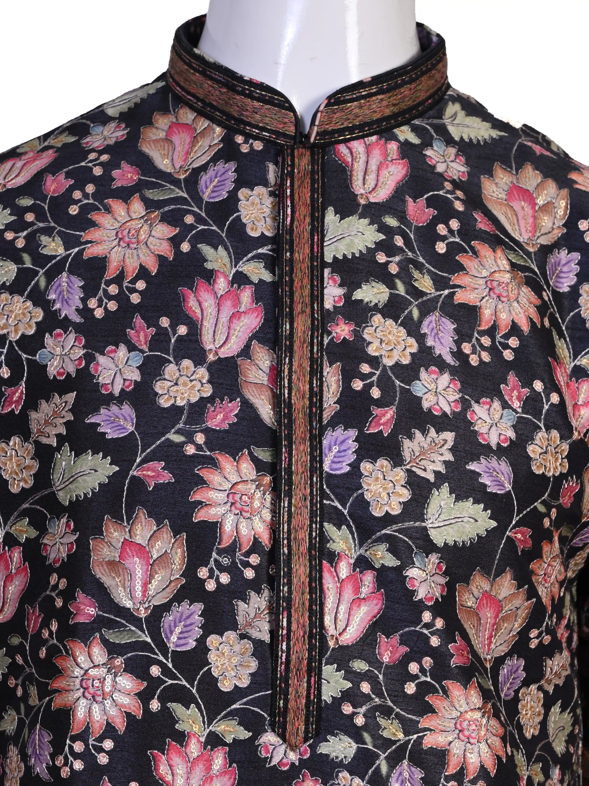 Man wearing a dark multi-color floral print kurta and white churidar pants, traditional ethnic wear.