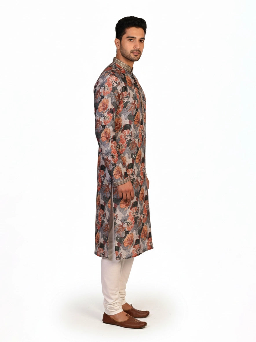 Man wearing a multi-color floral print kurta with an embellished neckline and cream churidar pants.