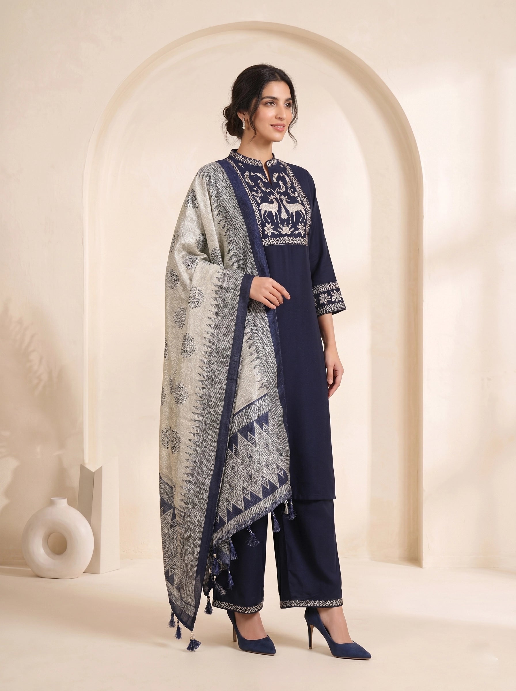 Navy blue embroidered kurti and pants set with a printed dupatta draped over the shoulder.