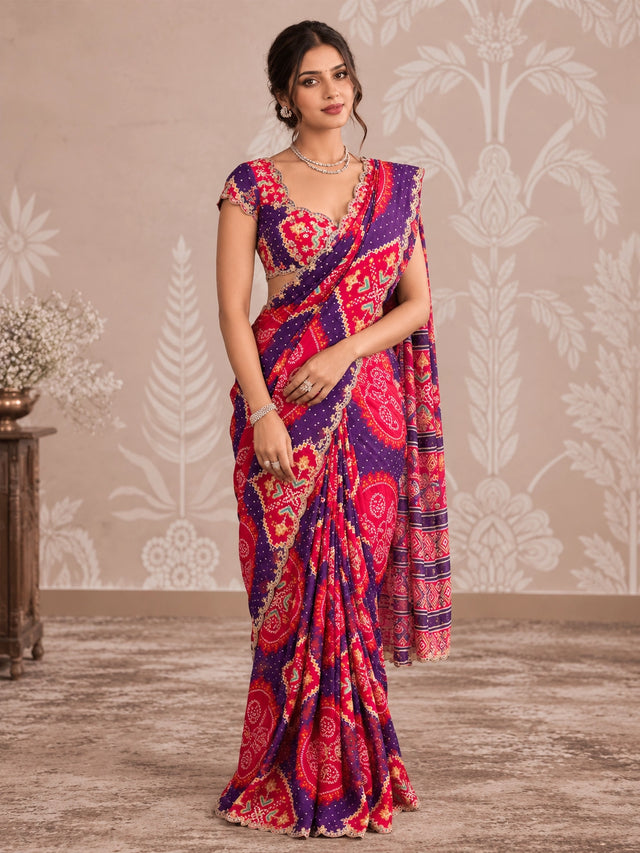 Woman in vibrant purple and pink printed saree with intricate patterns and scalloped border.