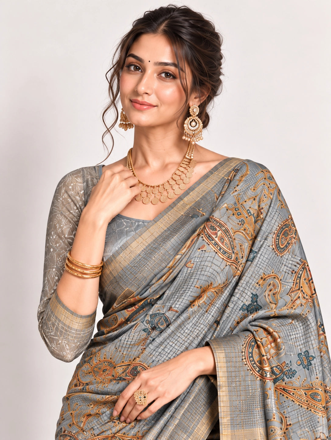 Woman in an elegant lavender grey saree with gold border and intricate paisley patterns.