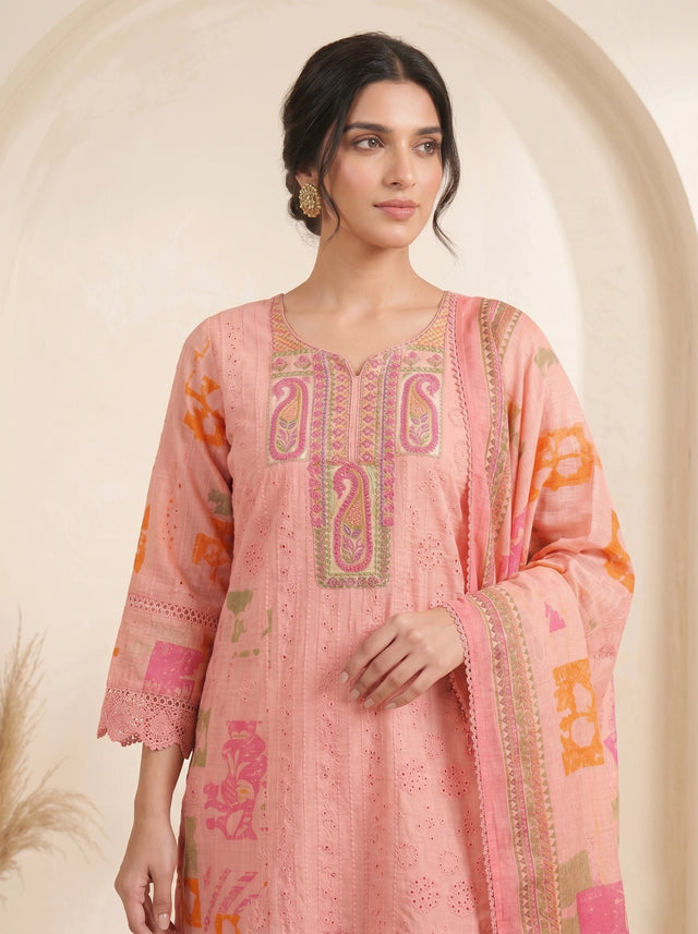 Woman wearing a pink printed cotton kurti set with palazzo pants and a dupatta, featuring eyelet details and block prints.