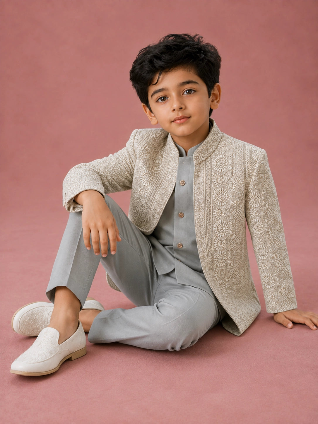 Young boy wearing a pista green Indo-Western suit with an intricately embroidered jacket.