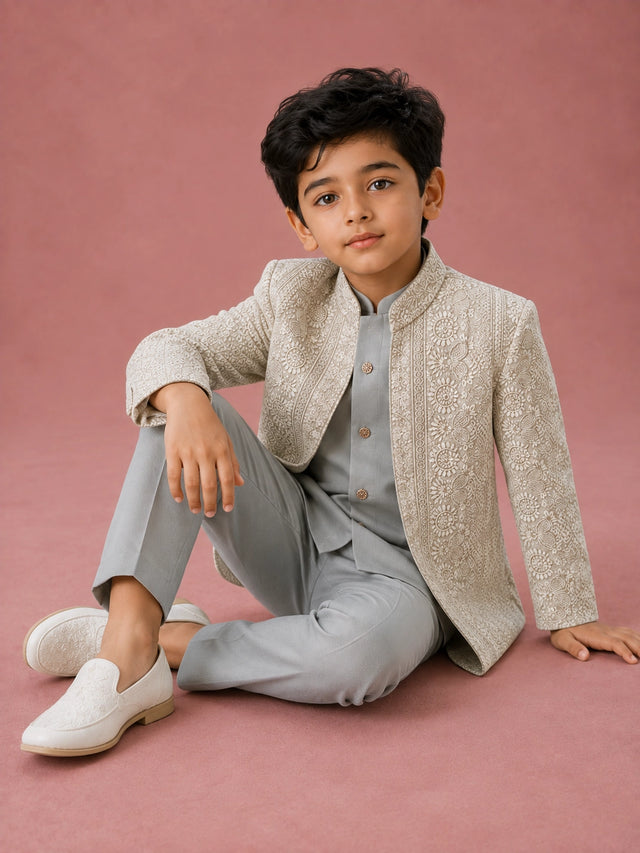 Young boy wearing a pista green Indo-Western suit with an intricately embroidered jacket.