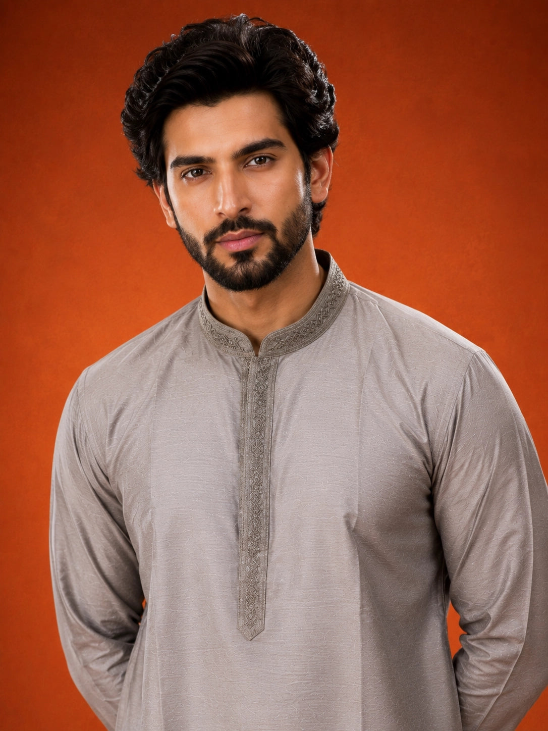 Man in elegant grey kurta with embroidered collar and white pajama set.