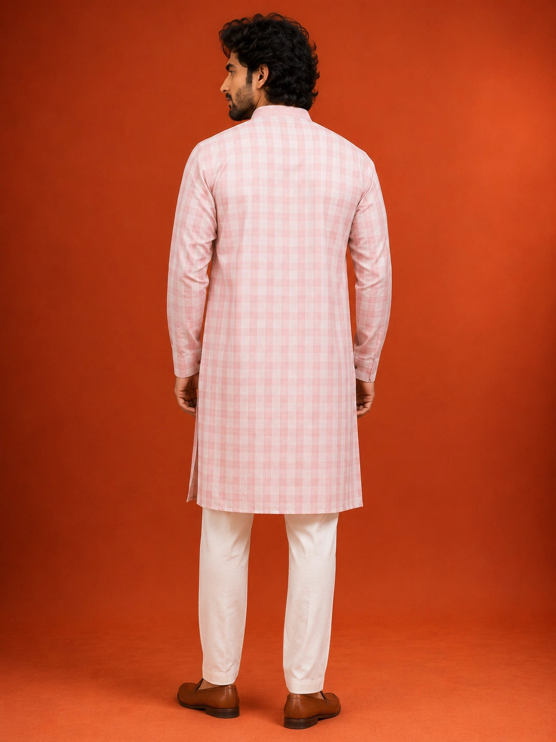 Man wearing a light pink checked kurta with a band collar and white pajama.