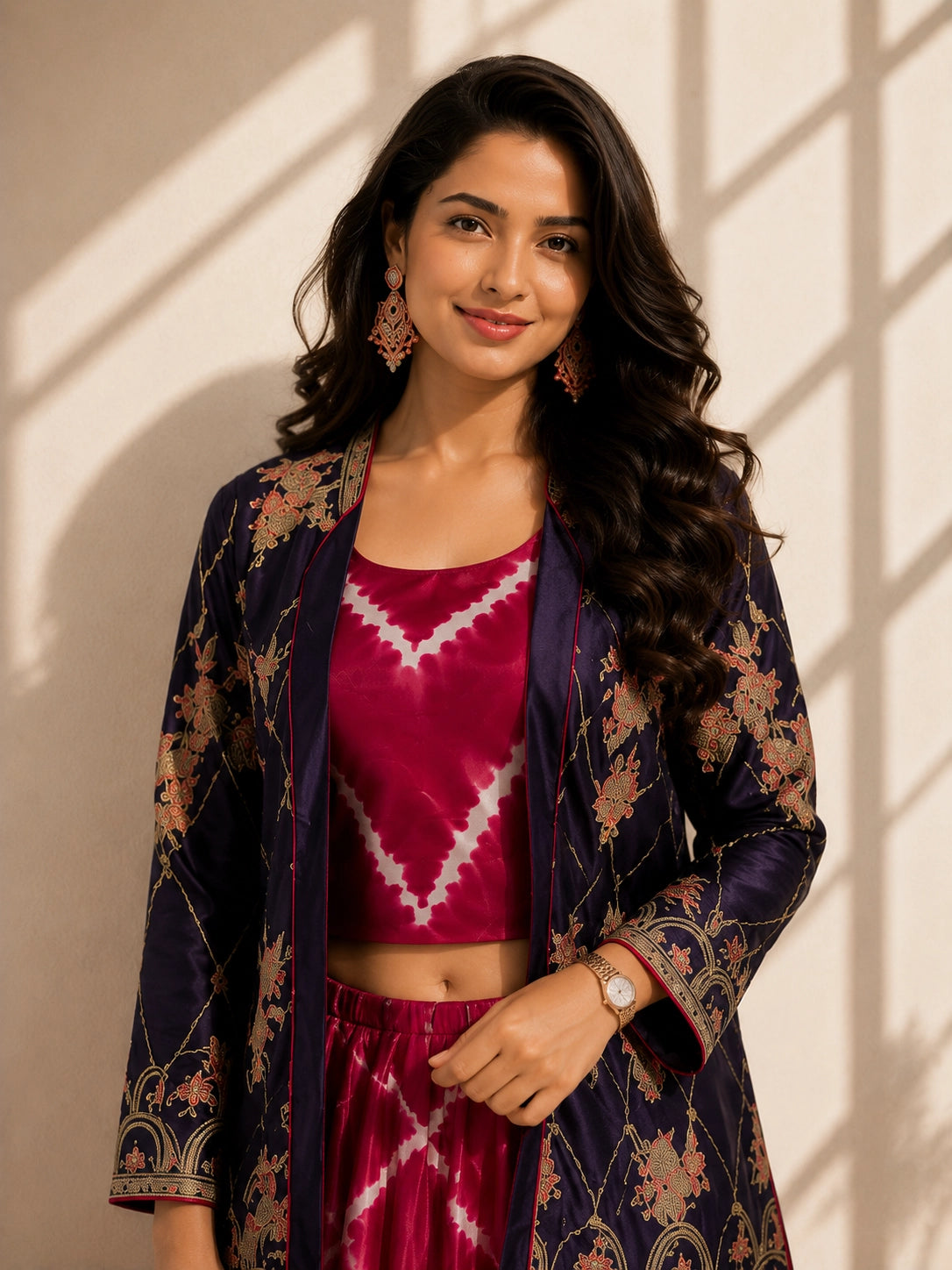Elegant woman wearing a blue embroidered jacket with a pink tie-dye kurti set.
