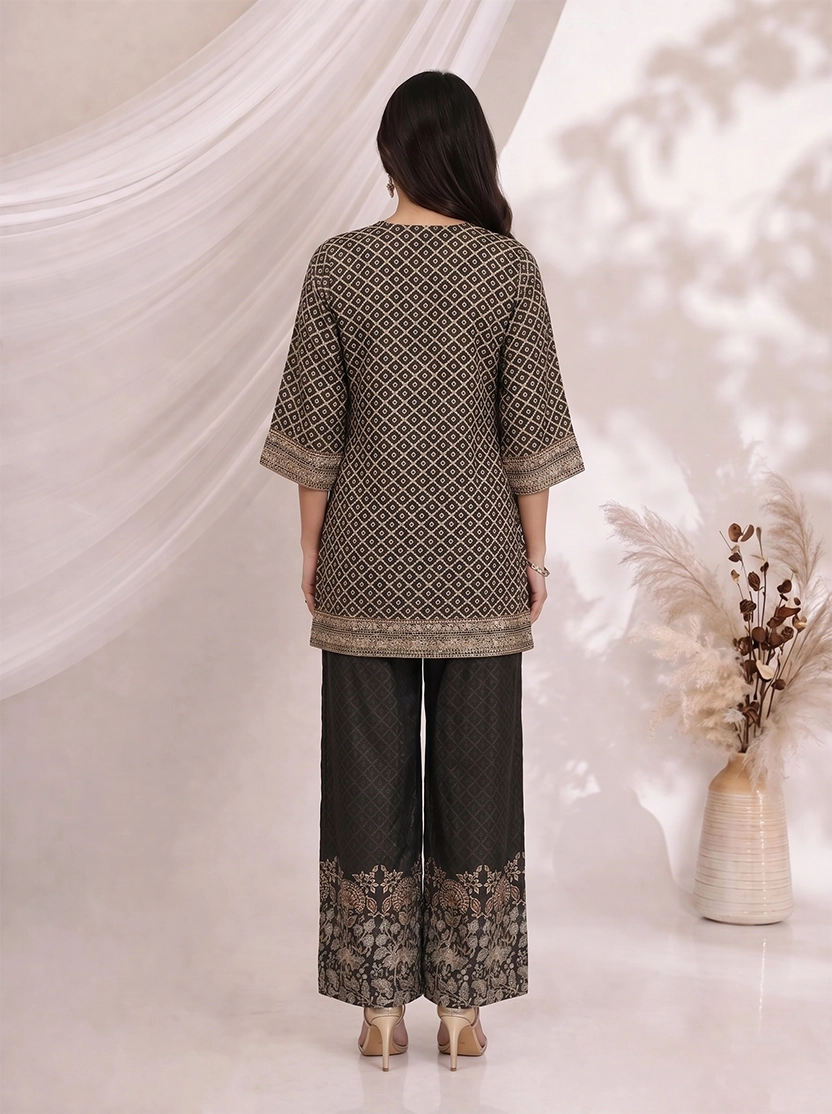 Woman wearing a black printed kurta with wide-leg pants, featuring floral motifs and a contrasting border.