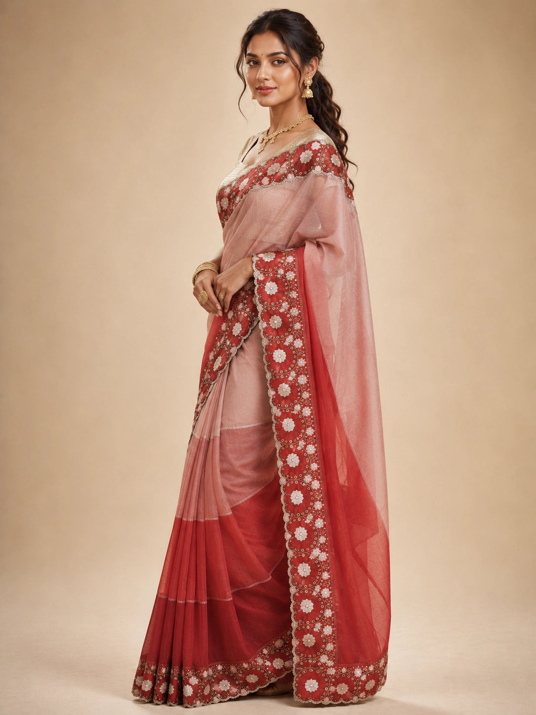Woman in an elegant red ombre  saree with intricate white floral embroidery.
