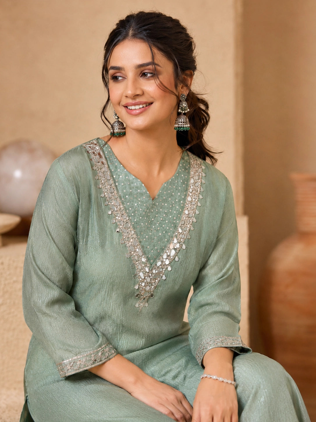 Woman wearing a green embroidered Sharara with silver embellishments on the neckline and cuffs.
