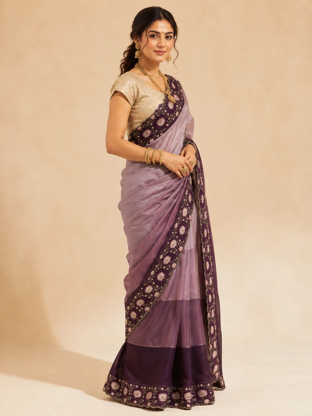 Woman in an elegant wine  saree with intricate floral embroidery and a golden blouse.